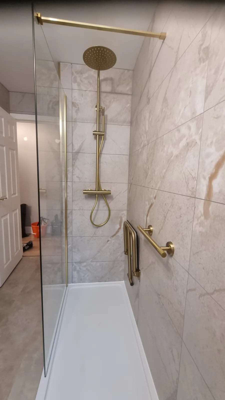 Brass shower fittings with marble-effect wall panels